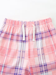 Pink plaid cotton shorts with elastic waistband and white drawstring detail.