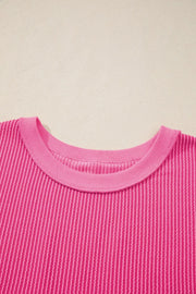 Pink ribbed maternity t-shirt with crew neck and textured vertical stripes.