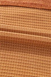 Caramel waffle knit henley top with contrast stitching detail.