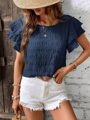 Dark blue smocked blouse with ruffled short sleeves and a textured finish.