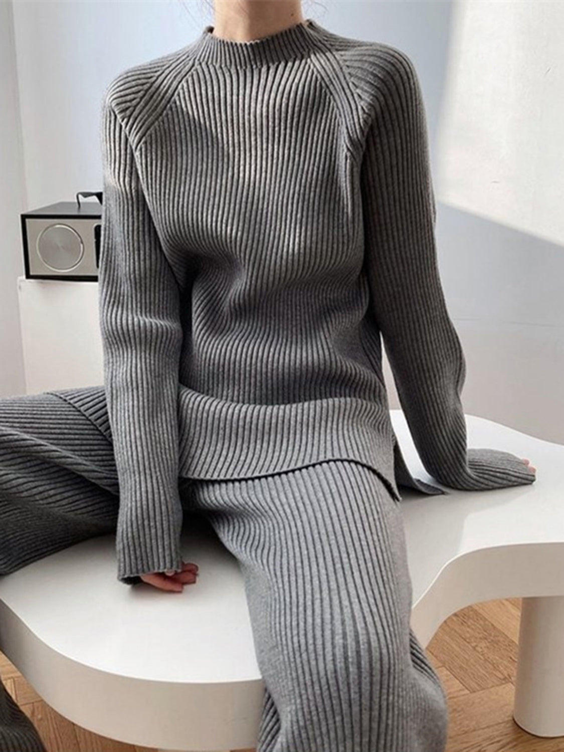 Asymmetric ribbed knit co-ord set in dark gray, featuring a mock neck sweater and wide-leg pants.