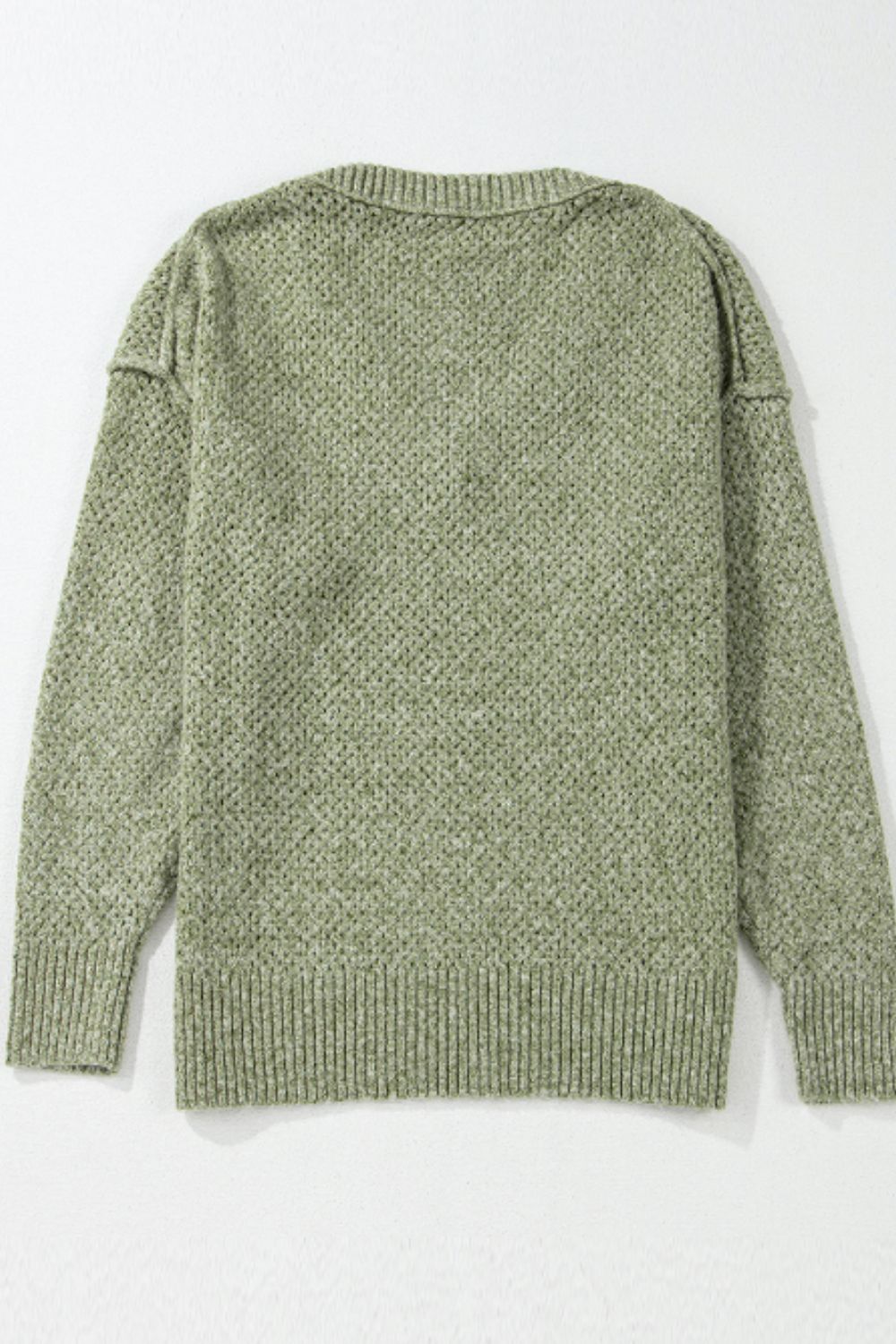 Open-knit slouchy V-neck sweater in matcha green with a textured pattern and ribbed cuffs and hem.