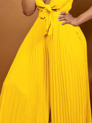 Yellow pleated wide leg romper with tie front detail.