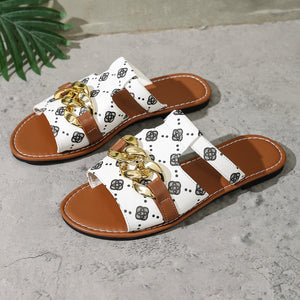 Patterned slide sandals in gray/white with brown straps and gold chain accent.