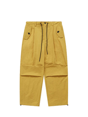 Ginger yellow cargo joggers with drawstring waist and button flap pockets.