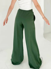 Dark green wide-leg lounge pants with pockets and a relaxed fit.