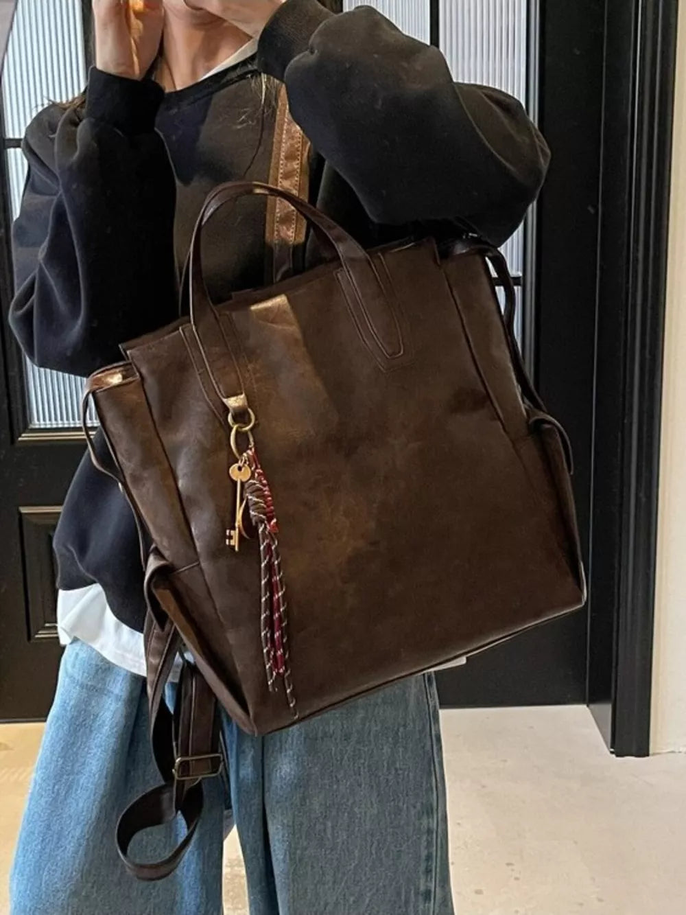 Convertible leather backpack in coffee brown with key charm detail