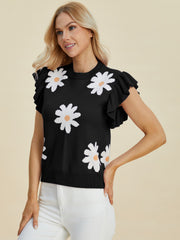 Black knit blouse with white daisy print and ruffled short sleeves