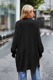 Black open-knit longline cardigan with side slits and textured sleeves.
