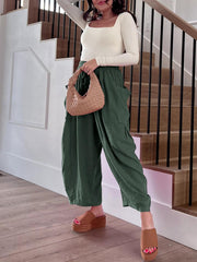 Dark green linen balloon trousers with cargo pockets and a drawstring waist.