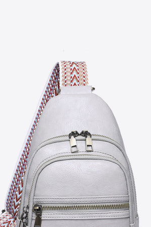 Geometric strap sling bag in Mid Gray with chevron strap detail and double zipper closure.