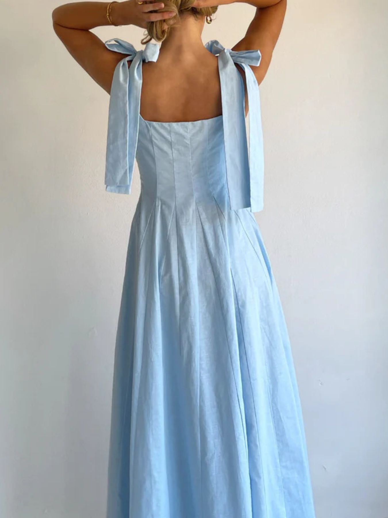 Light blue maxi dress with bow-tie shoulder straps and a square neckline.