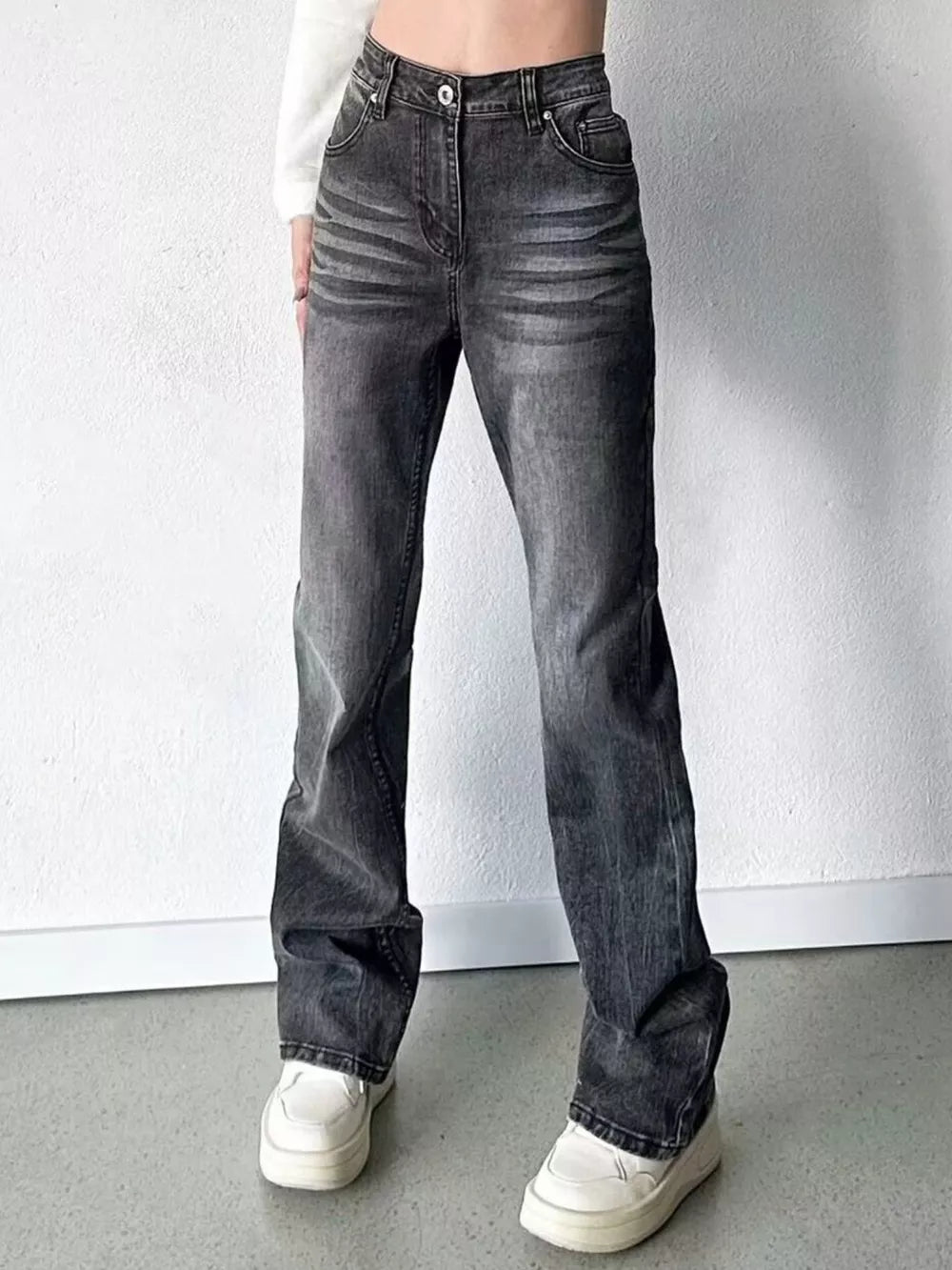 Men's black high-waisted straight leg jeans with button closure and faded details.