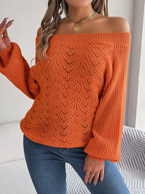 Pumpkin open-knit off-shoulder sweater with voluminous sleeves and intricate leaf pattern.
