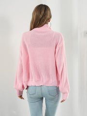 Blush pink ribbed knit zip-up sweater with a mock neck and long sleeves.