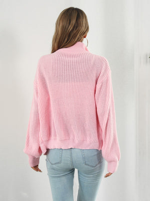 Blush pink ribbed knit zip-up sweater with a mock neck and long sleeves.