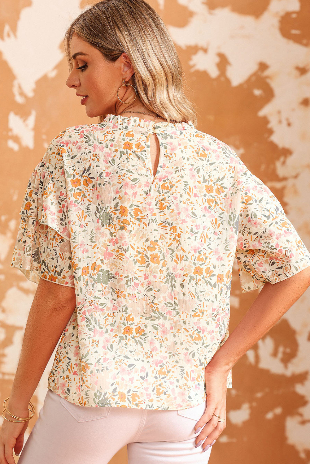 Floral ruffle trim blouse with keyhole back and short flutter sleeves.