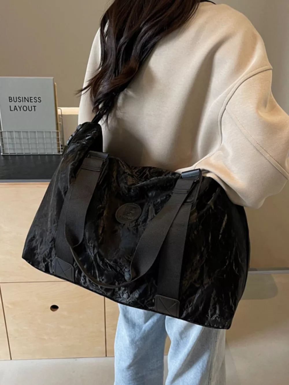 Black Oxford cloth travel bag with textured finish and dual straps