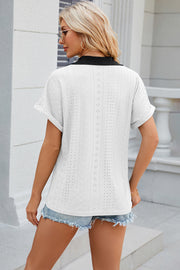 White perforated polo top with black collar and short sleeves