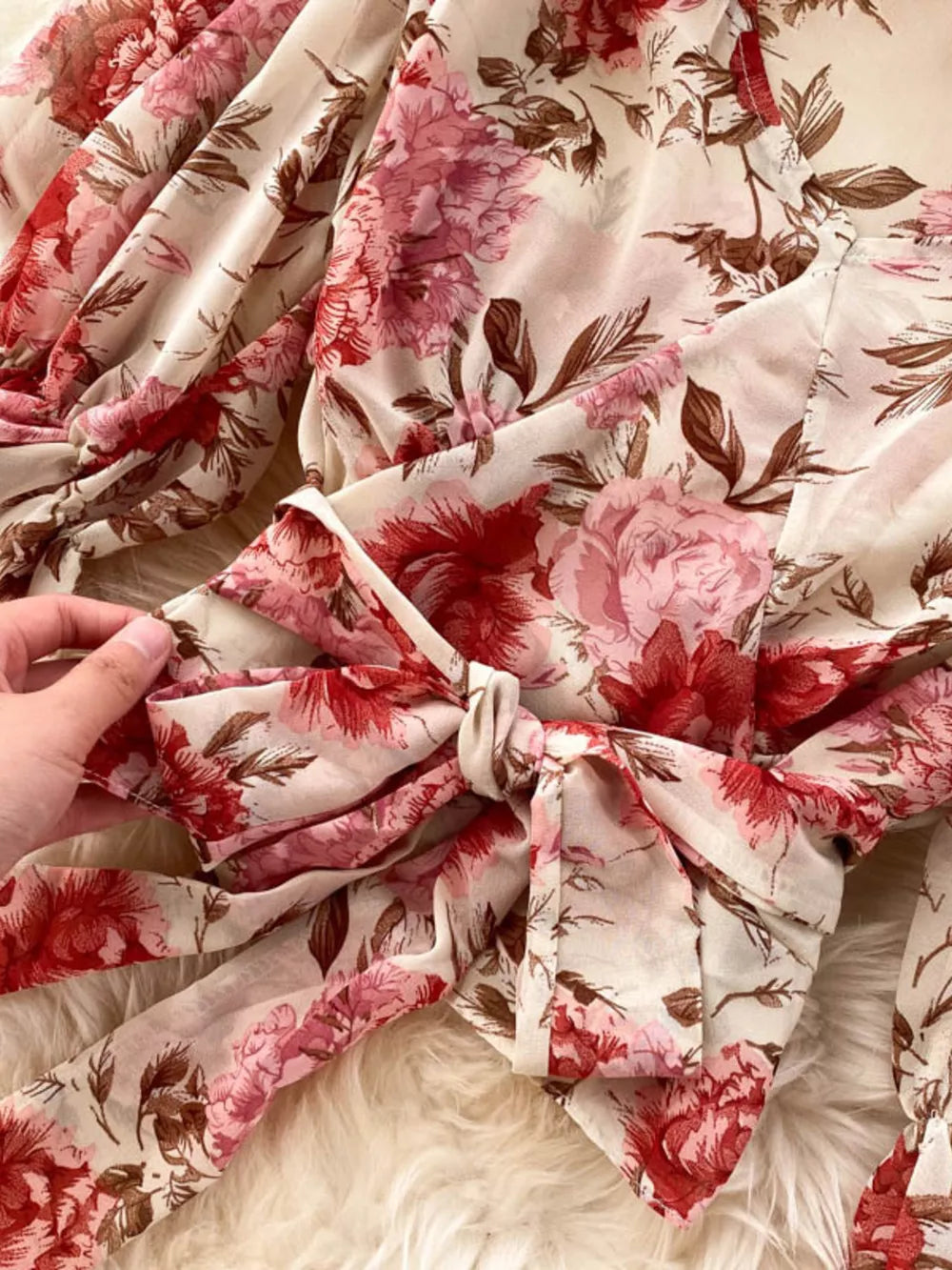 Chic floral crop top with bow detail in pink and red on cream fabric.