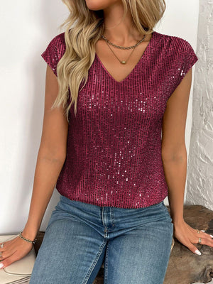 Crimson sequined cap-sleeve V-neck blouse with allover sparkle.