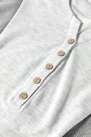 Gray waffle knit henley top with wooden buttons and a colorblock detail.