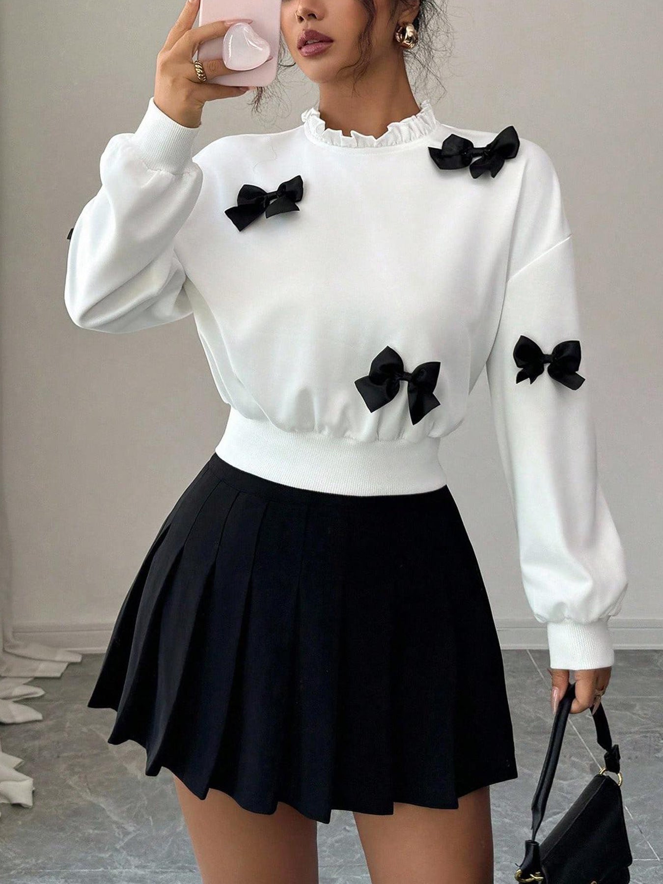 White crew neck sweatshirt with black bow appliques and ruffled collar