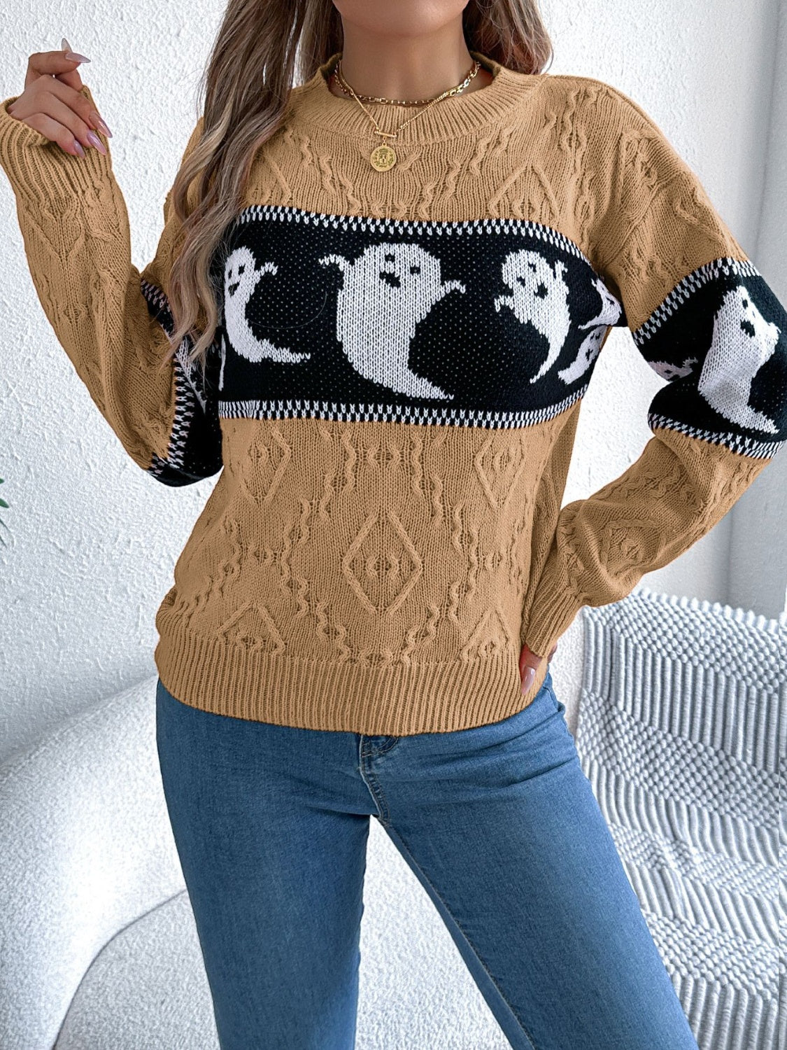 Camel cable knit crewneck sweater with a black band featuring white ghost motifs.