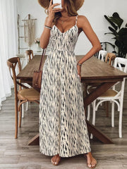 Backless wide-leg jumpsuit in cream with black abstract print, spaghetti straps, and V-neck.