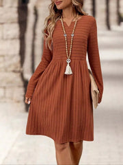 Ribbed knit A-line dress with long sleeves in rust, V-neck, and a gathered skirt.