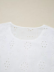 White cotton blouse with delicate eyelet embroidery and floral details.