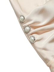 Elegant V-neck ruched bodysuit in champagne satin with pearl and rhinestone button details.