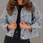 Light wash denim jacket with pearl embellishments and distressed details.