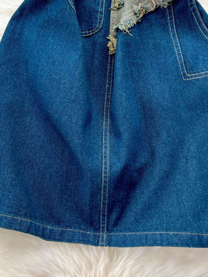 Denim overall skirt with distressed hem and white contrast stitching.