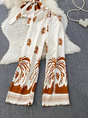 Tropical print two-piece set with belted detail in white and brown polyester, featuring wide-leg pants and a tie-front top.