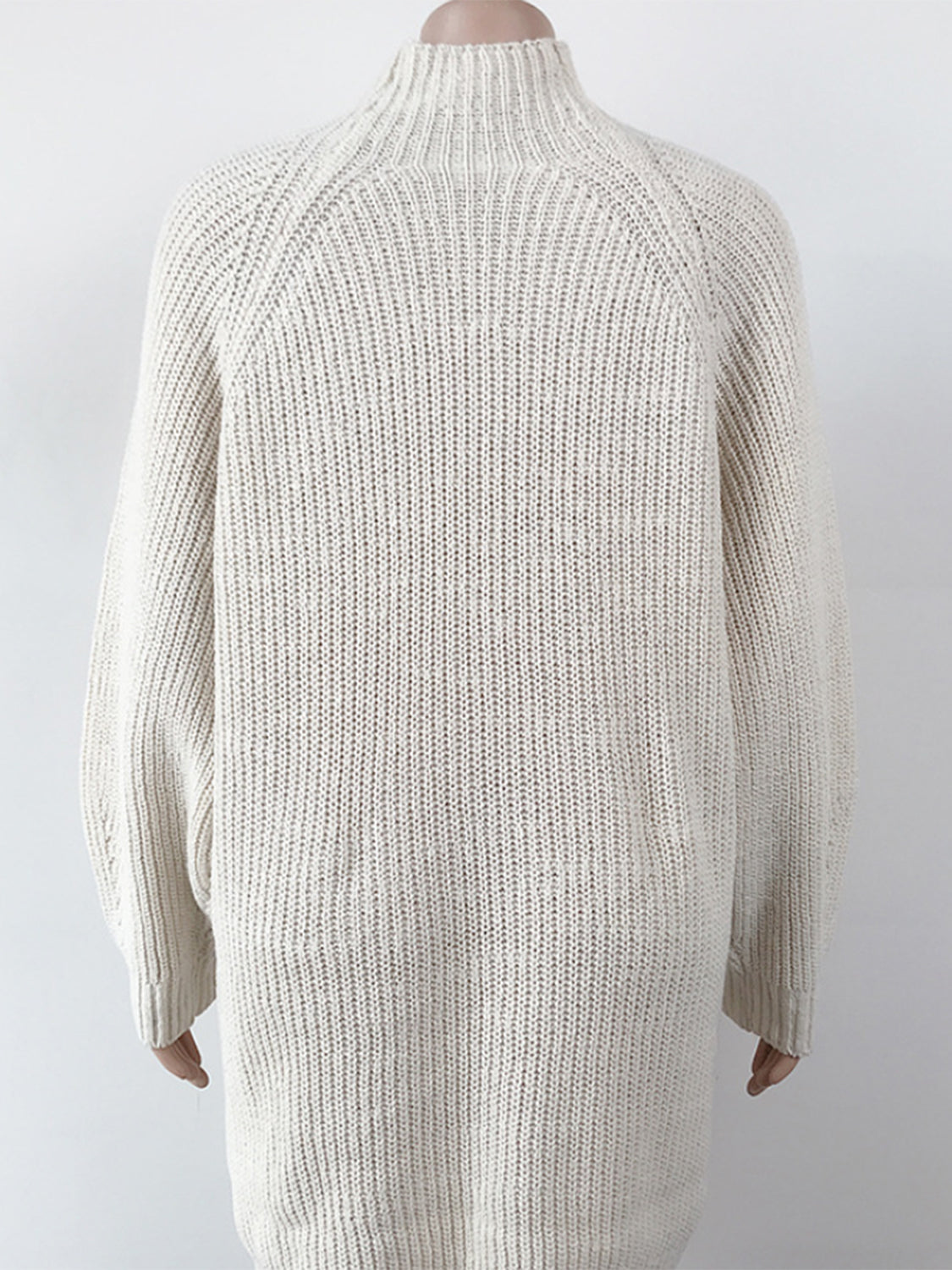 Cream ribbed knit cocoon turtleneck dress with long sleeves and a relaxed fit.