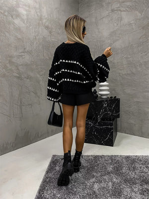 Black knit sweater with textured stripes and balloon sleeves, crew neck.