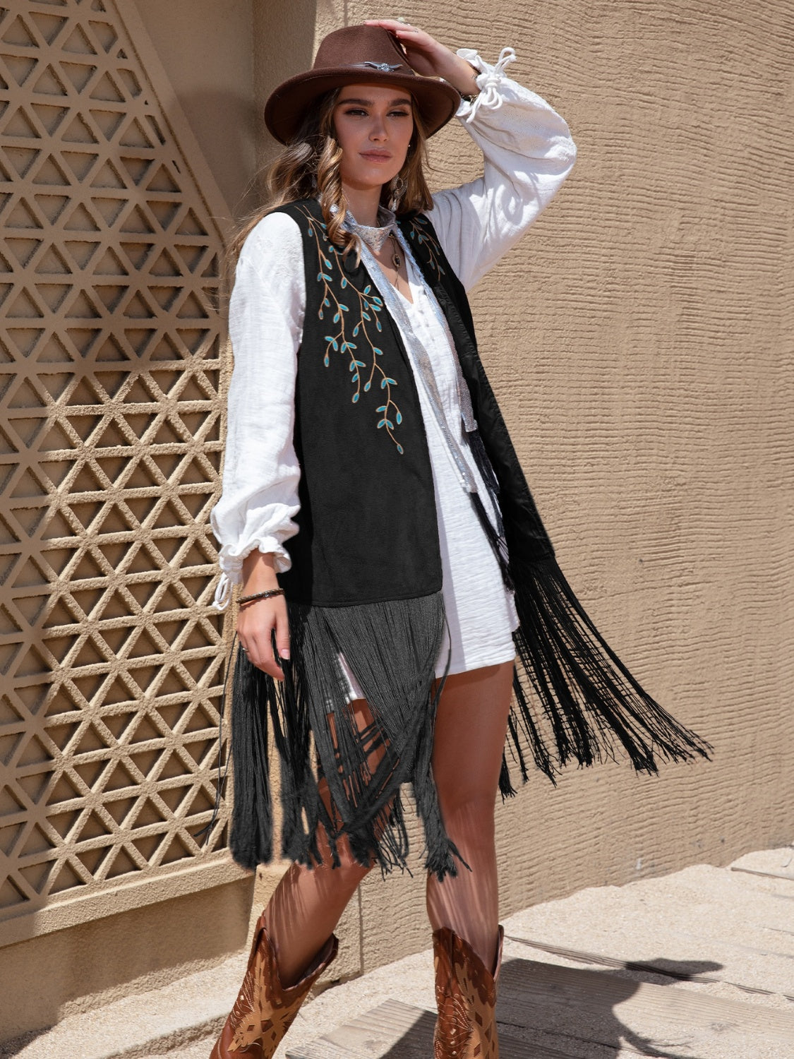 Black faux suede vest with turquoise embroidery and long fringe detail.