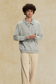 Gray oversized polo sweatshirt with collar and long sleeves, made of soft cotton.