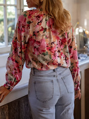 Frill trim button-up shirt with a vibrant floral print, long sleeves, and a relaxed fit.