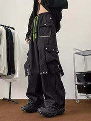 Men's black relaxed-fit cargo pants with multiple pockets and neon green drawstring.
