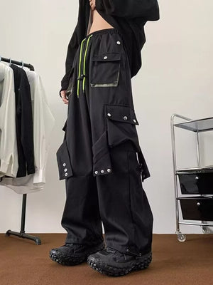 Men's black relaxed-fit cargo pants with multiple pockets and neon green drawstring.