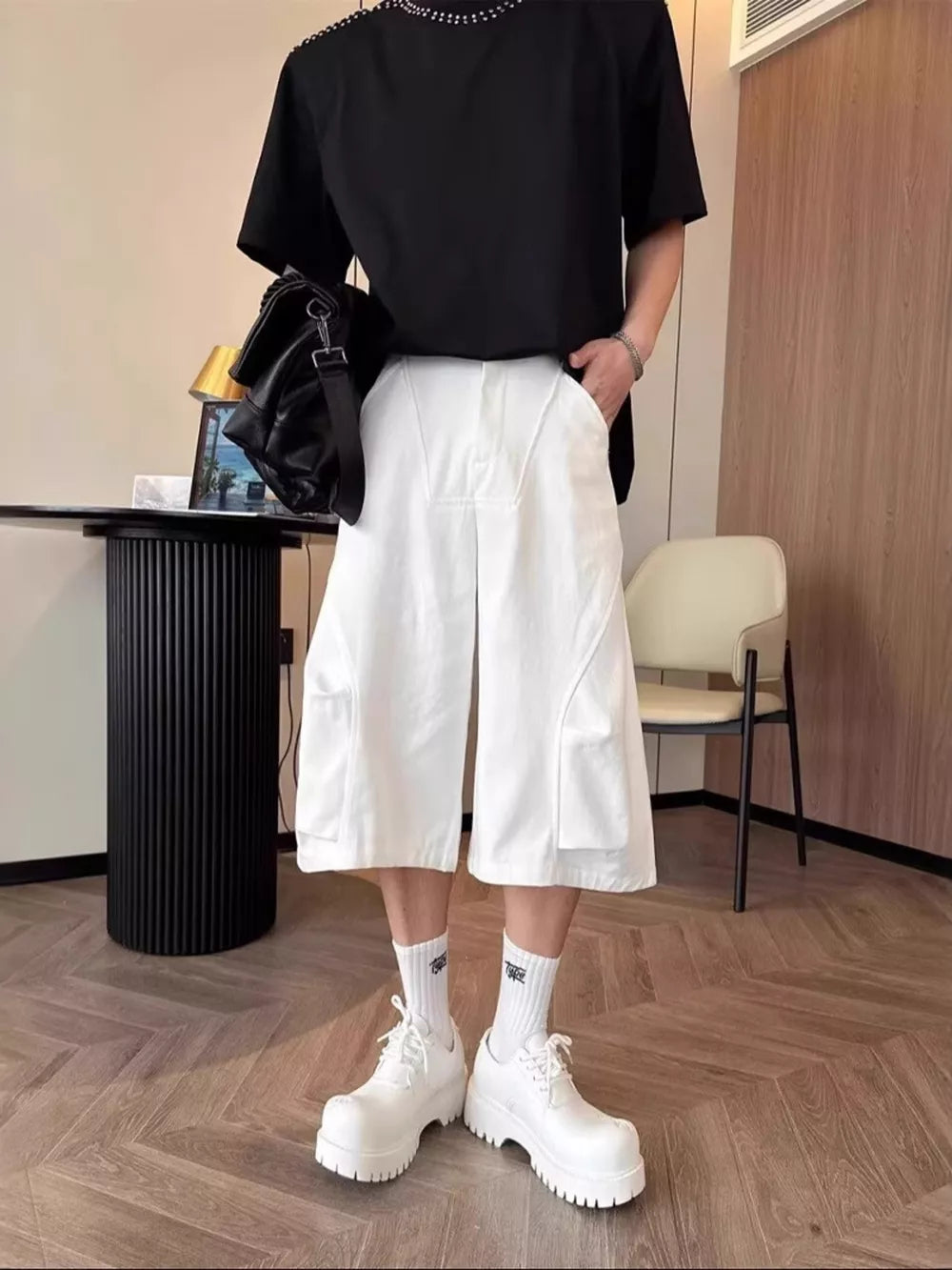 White relaxed fit cropped cargo pants with large side pockets and a pleated front.