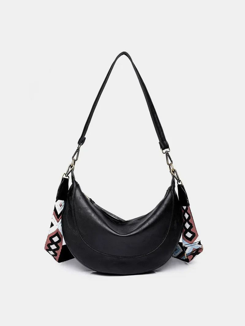 Black leather crescent crossbody bag with geometric strap