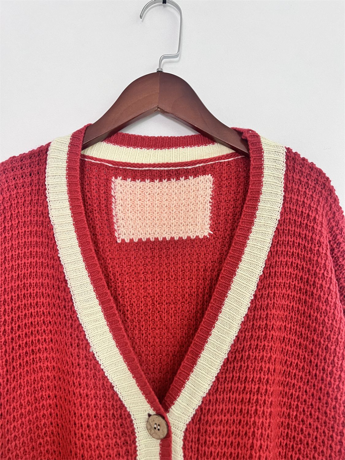 Scarlet textured knit cardigan with cream varsity stripes and a single button closure.