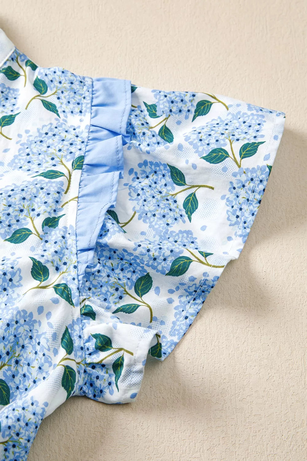 Hydrangea print cotton blend midi dress with flutter sleeves and ruffled neckline detail.