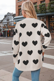 Beige acrylic knit cardigan with black heart print and crew neck.