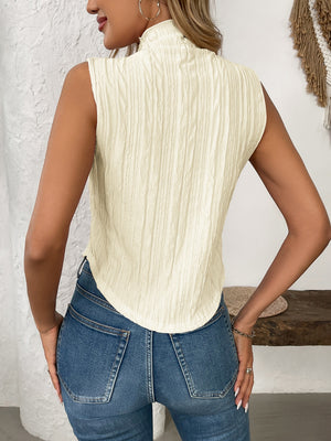 Textured sleeveless mock neck top in cream with a ruched pattern.