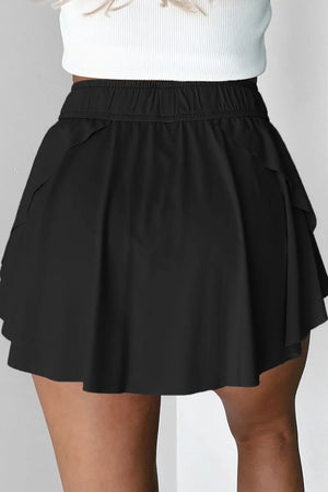 Black flared skort with elasticated tie waist and layered hem detail.