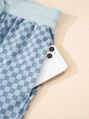 Light blue checkerboard loungewear shorts with a phone in the pocket.